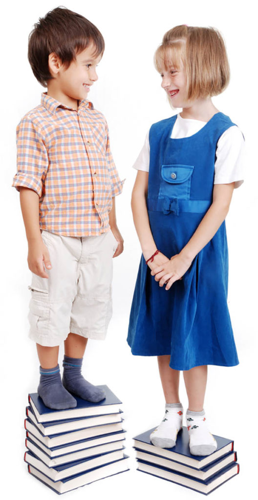 boy and girl standing on books